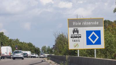 Ein Schild mit der Aufschrift „Voie réservée“ weist neben einer Autobahnauffahrt auf eine Spur für Fahrgemeinschaften, Taxis und Busse hin. 