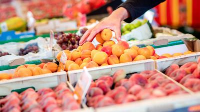 Ein Verkäufer greift an einem Obst- und Gemüsestand auf dem Wochenmarkt in eine Kiste mit Aprikosen. Die hohe Inflation ist einer Umfrage zufolge derzeit die größte Sorge der Menschen in Deutschland. (zu dpa «Umfrage: Inflation derzeit größte Sorge der Menschen in Deutschland») +++ dpa-Bildfunk +++