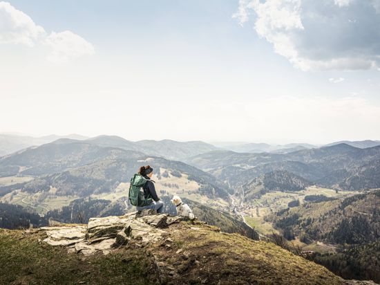 Eine Wanderin sitzt auf dem Gipfel des Kandel  in Baden-Württemberg.