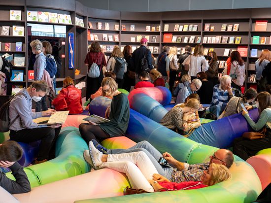 Besucher sitzen auf der Frankfurter Buchmesse 2022 im Pavilion des Gastlandes Spanien vor einer Bücherwand. Die 75. Buchmesse startet am kommenen Dienstag, 17. Oktober 2023.
