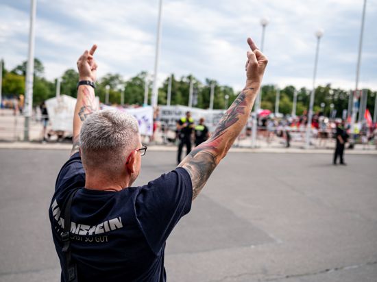 Ein Rammstein Fan zeigt der Demonstration «Kein Rammstein-Konzert in Berlin!» vor dem Olympiastadion in Berlin den Mittelfinger. Am Samstag findet das erste von drei Rammstein-Konzerten im Berliner Olympiastadion statt. +++ dpa-Bildfunk +++