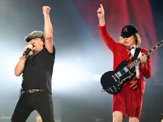 Der Sänger Brian Johnson und der Gitarrist der australischen Rockband AC/DC, Angus Young, stehen in Berlin im Olympiastadion auf der Bühne. 
