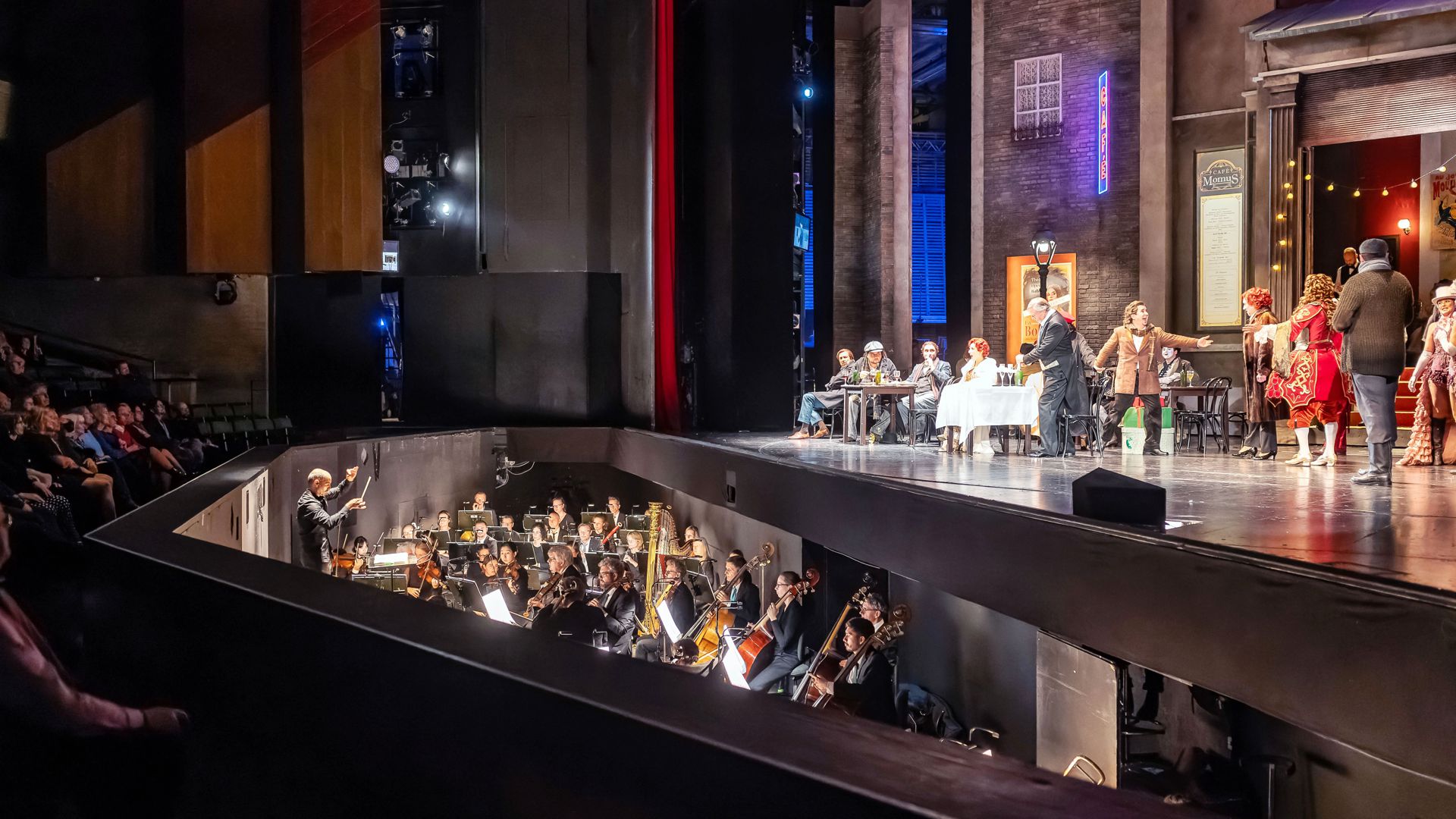 Blick seitlich auf den Orchestergraben und die Bühne im Großen Haus des Staatstheaters Karlsruhe während einer Vorstellung der Oper „La Bohème“ im Oktober 2023.