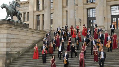 Musikerinnen und Musiker der Klassischen Philharmonie Bonn stehen auf einer Treppe vor deinem Säulenportal.