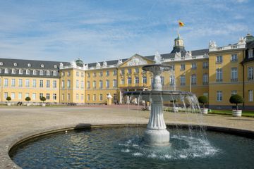Blick auf die Fassade des Karlsruher Schlosses mit Brunnen.
