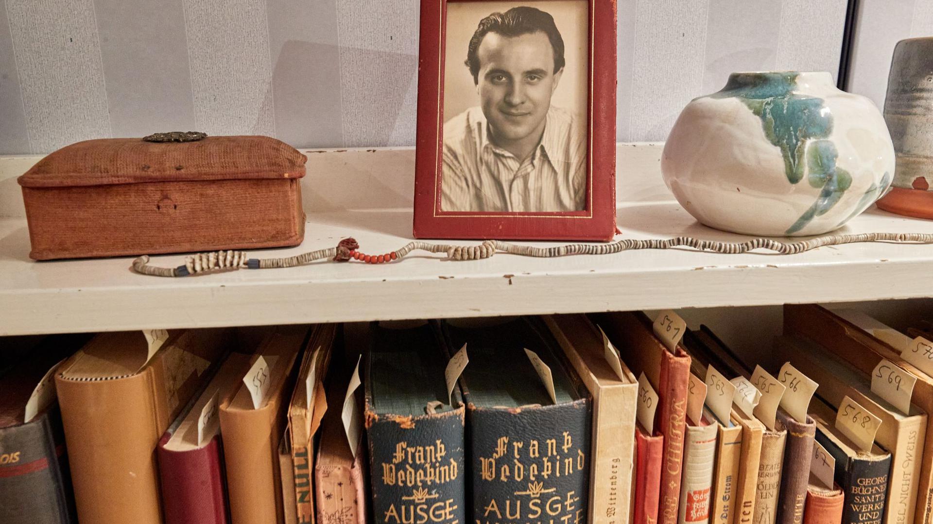 Ein Bilderrahmen mit einem Foto des Schriftstellers Wolfgang Borchert steht auf einem Bücherregal in der „Borchert-Box“. Am 20. Mai wäre Borchert 100 Jahre alt geworden.