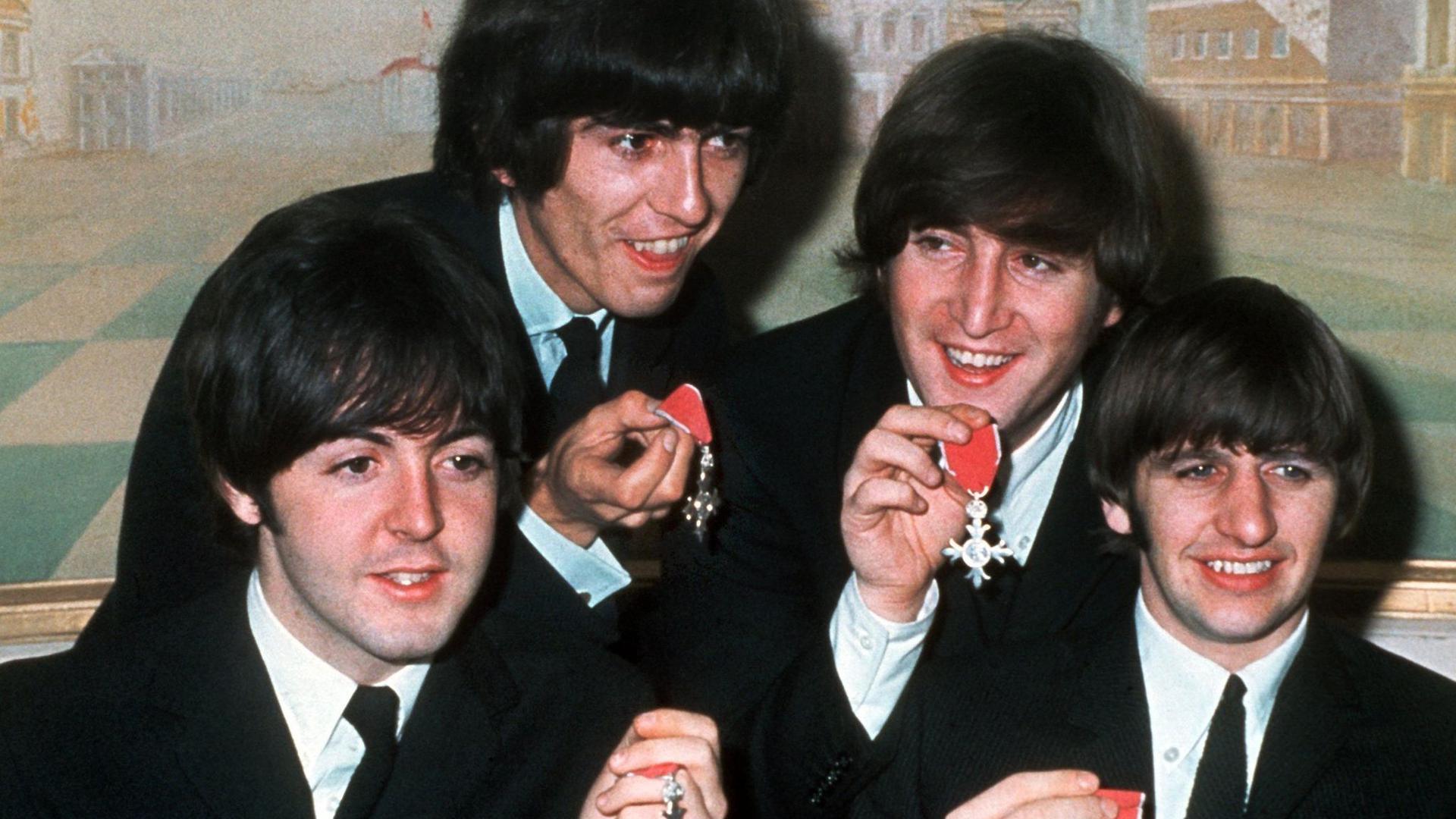 Die vier „Pilzköpfe“ der britischen Popgruppe „The Beatles“(l-r): Paul McCartney, George Harrison, John Lennon und Ringo Starr mit den Orden „Member of the Order of the British Empire“.