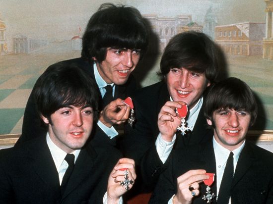 Die vier „Pilzköpfe“ der britischen Popgruppe „The Beatles“(l-r): Paul McCartney, George Harrison, John Lennon und Ringo Starr mit den Orden „Member of the Order of the British Empire“.