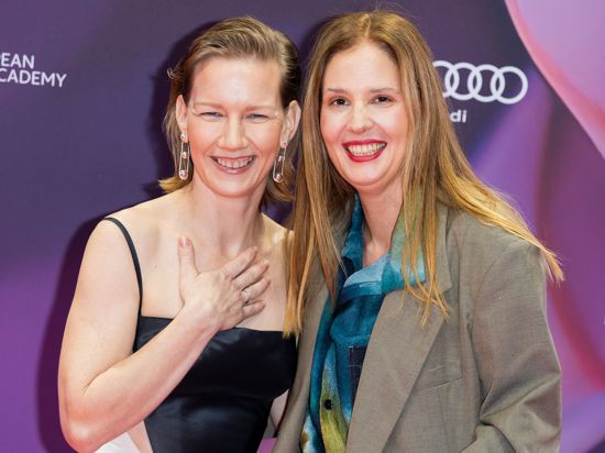 Für sie hat sich der Abend gelohnt: Schauspielerin Sandra Hüller (l) und Regisseurin und Drehbuchautorin Justine Triet können sich über ihre Trophäen für „Anatomie eines Falls“ freuen.