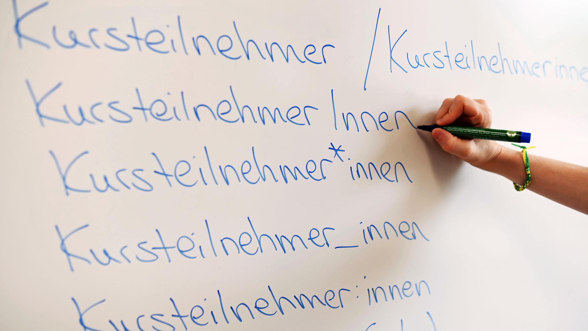 In der Volkshochschule (VHS) Karlsruhe steht an einem Whiteboard das Wort Kursteilnehmer in verschiedenen Gender-Schreibweisen.