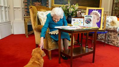 Lebenslange Zuneigung: Auf dem im Februar 2022 aufgenommenen Bild im Windsor-Palast streichelt Königin Elizabeth II. zärtlich einen ihrer geliebten Hunde, den Corgi Candy. 