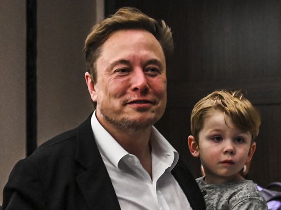 Elon Musk mit einem seiner Kinder im Arm.