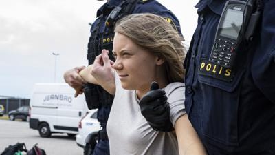 Zwei Politisten tragen bei einem Straßenprotest in Schweden die Klima-Aktivistin Greta Thunberg weg. 