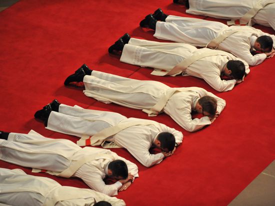 Sieben der neun diesjährigen Priesteranwärter des Erzbistums Freiburg liegen am Sonntag (09.05.2010) während ihrer Weihe zum Priester als Zeichen der Demut bäuchlings auf einem roten Teppich im Freiburger Münster. Bei der jährlich stattfindenden feierlichen Zeremonie wurde den jungen Diakonen das Sakrament der Priesterweihe gespendet. Foto: Rolf Haid dpa/lsw ++ +++ dpa-Bildfunk +++
