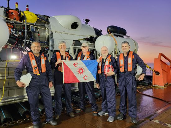 Nach acht Stunden unter Wasser: Das Team um Alex Waibel (2. von rechts) posiert bei der Rückkehr an Bord des Expeditionsschiffs Horizon Arctic im Nordatlatik. Im Hintergrund ist das Mini-U-Boot „Titan“ zu sehen.