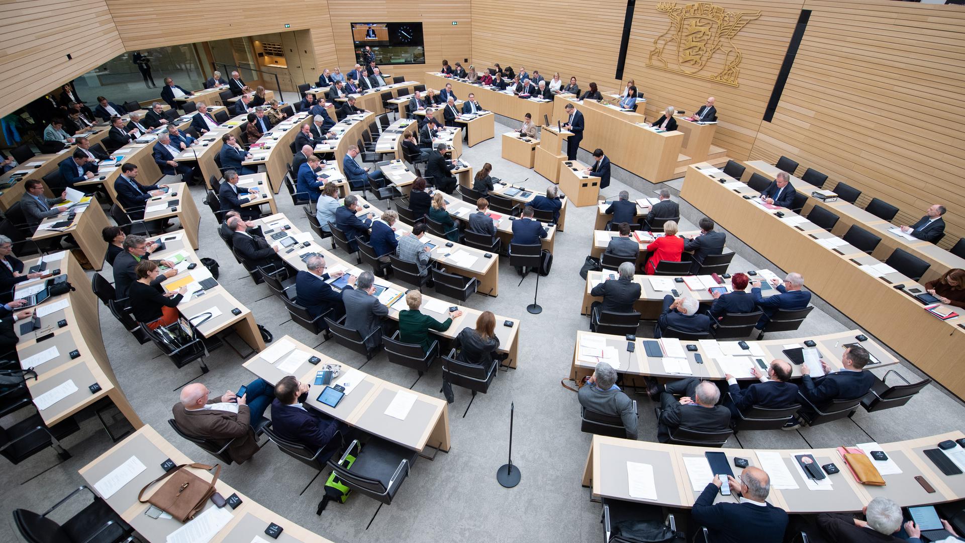 Abgeordnete sitzen im Stuttgarter Landtag auf ihren Plätzen. 