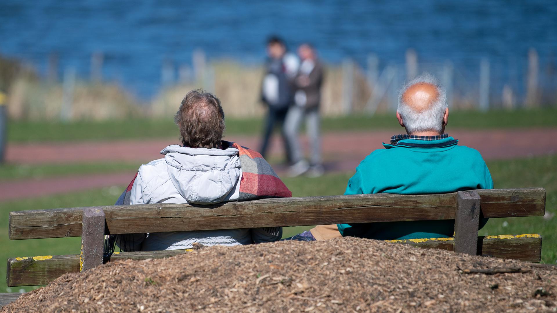 Ein älteres Paar sitzt auf einer Bank am Max-Eyth-See. 