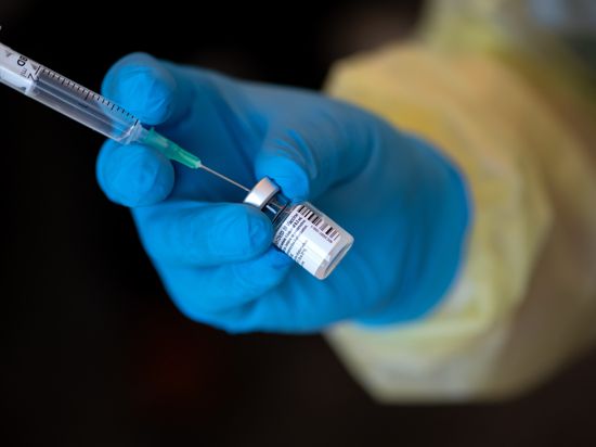 Eine Mitarbeiterin vom Bayerischen Roten Kreuz (BRK) bereitet in einem Impfzentrum den Impfstoff von Biontech/Pfizer gegen das Coronavirus SARS-CoV-2 für eine Impfung vor. 