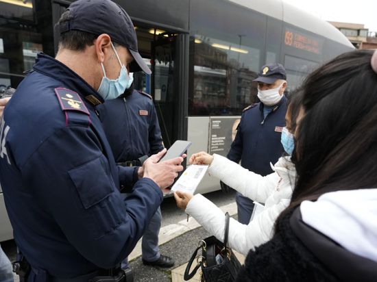 Polizisten kontrollieren den «Grünen Pass» von Fahrgästen öffentlicher Verkehrsmittel in Italien.