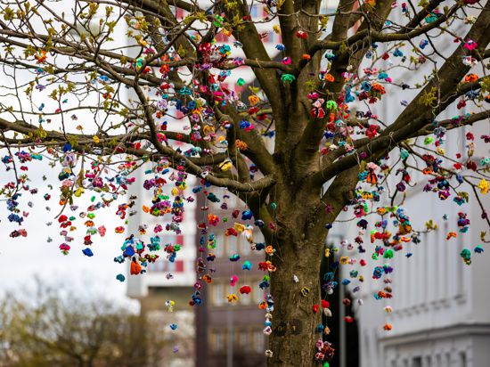 Gehäkelte Schmetterlinge hängen von den Ästen eines Baumes am Lichtenbergplatz. Die Initiatorinnen vom Yarn Bombing Kollektiv wollen damit Lichtblicke und Optimismus in die Pandemiezeit bringen.