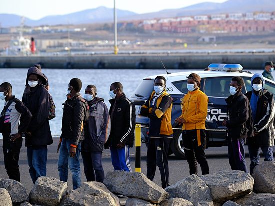 Migranten stehen Schlange, nachdem sie auf Fuerteventura an Land gegangen sind. 58 Migranten, die aus Afrika nach Spanien gelangen wollten, wurden in der Nähe der Insel Fuerteventura gerettet. +++ dpa-Bildfunk +++