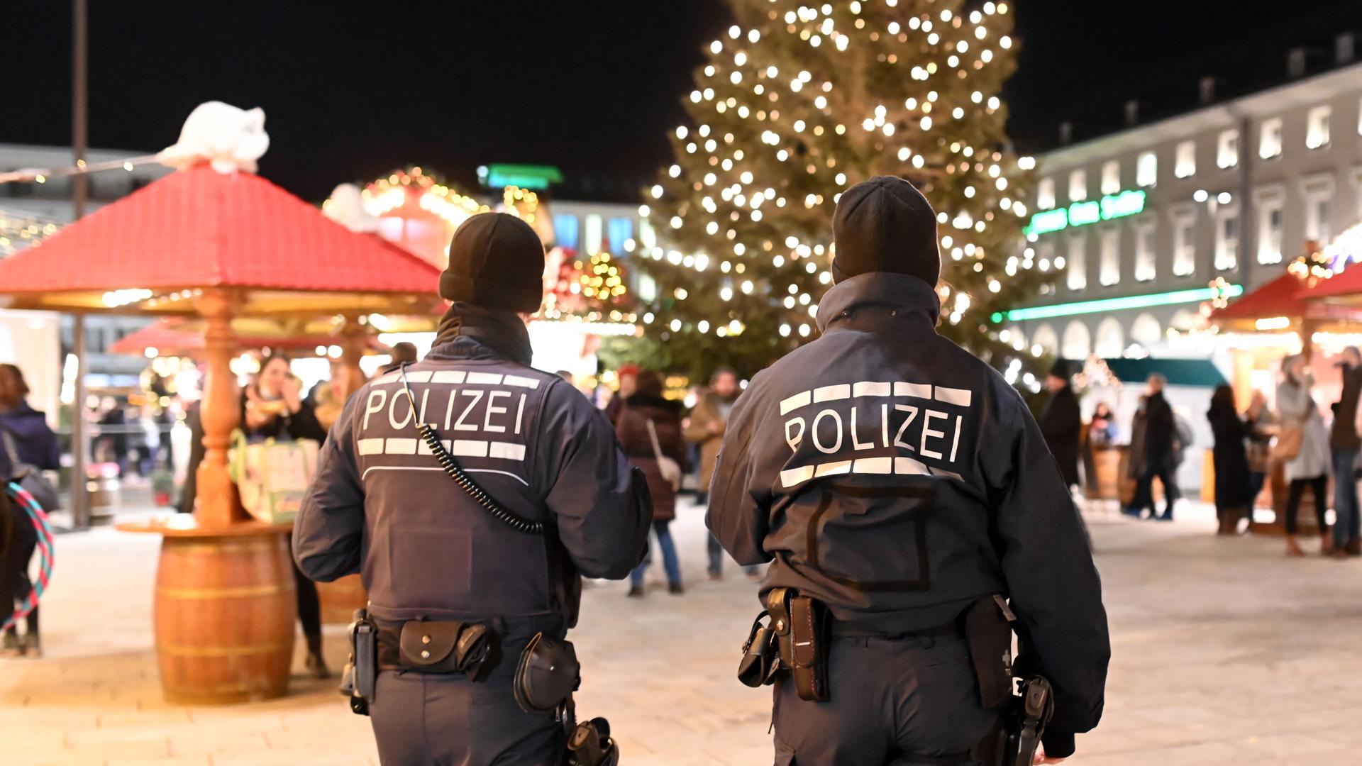 Polizisten gehen über den Weihnachtsmarkt in Karlsruhe.
