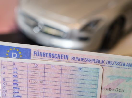 ILLUSTRATION - Zwei Führerscheine liegen vor einem Modellauto auf einem Tisch (gestellte Szene). Der verpflichtende Führerschein-Umtausch stellt die Führerscheinstellen in Sachsen-Anhalt vor eine erhebliche Belastungsprobe. (zu dpa «Umtausch von Führerscheinen: Kreise und Städte werden Frist verfehlen») +++ dpa-Bildfunk +++