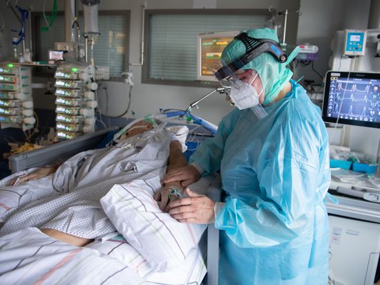 Eine Intensiv-Pflegerin versorgt einen schwer an Corona erkrankten Patienten auf der Intensivstation des Klinikums in Fulda. Viele Patienten mit schweren Verläufen liegen mehrere Wochen auf der Intensivstation, rund die Hälfte der künstlich beatmeten Patienten stirbt. +++ dpa-Bildfunk +++