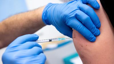 Ein Mensch erhält eine Impf-Spritze.
