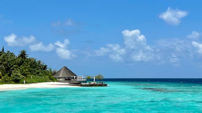Türkises Wasser, blauer Himmel, weißer Sand, grüne Palmen: Dieser Blick im Huvafen Fushi fasst gut zusammen, warum die Malediven für viele ein Sehnsuchtsziel sind.