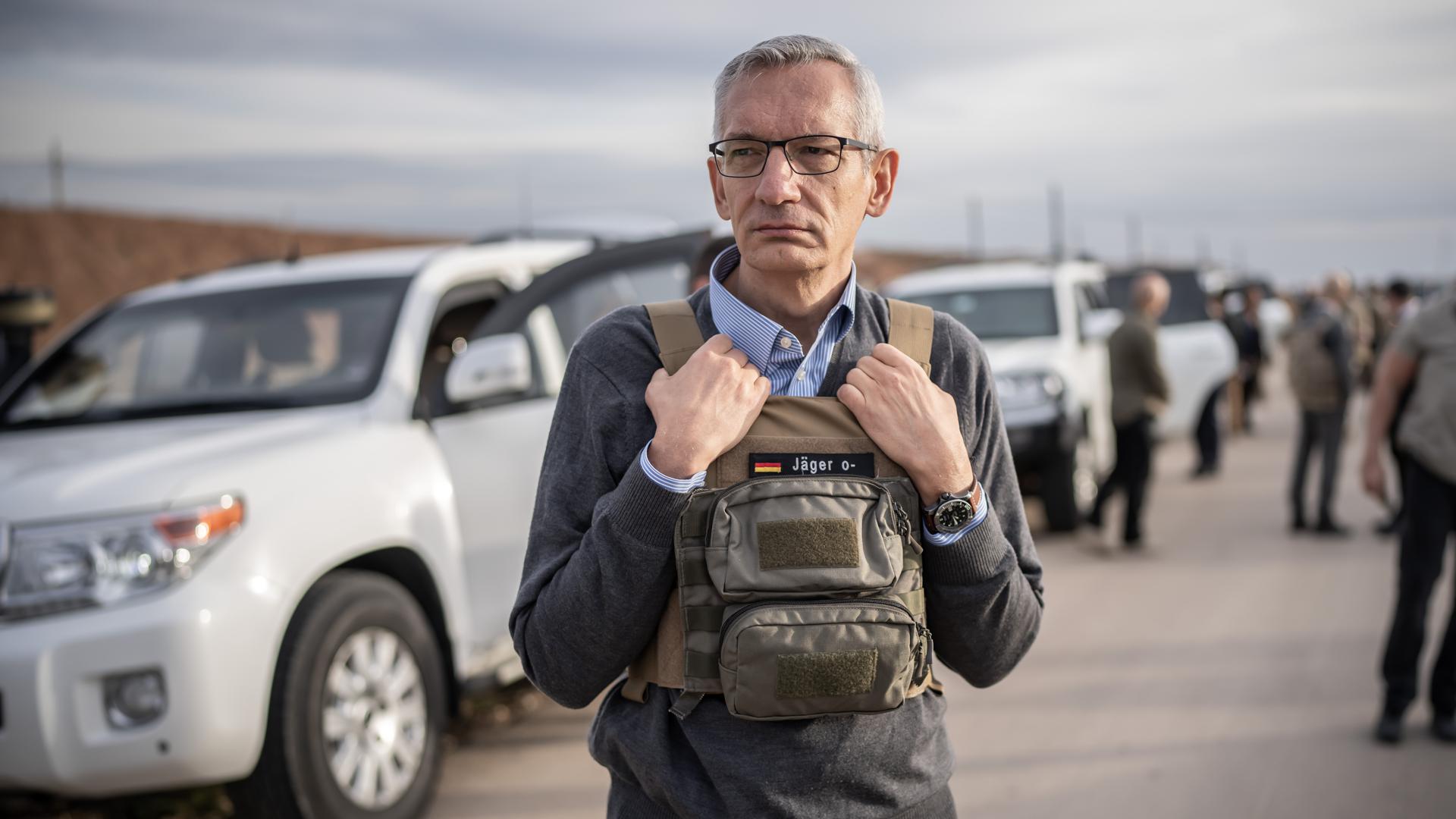 Martin Jäger, deutscher Botschafter im Irak, steht mit Schutzweste auf dem Weg zum zerstörten Stadtzentrum von Sindschar. 