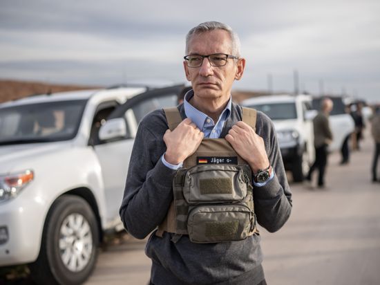 Martin Jäger, deutscher Botschafter im Irak, steht mit Schutzweste auf dem Weg zum zerstörten Stadtzentrum von Sindschar. 