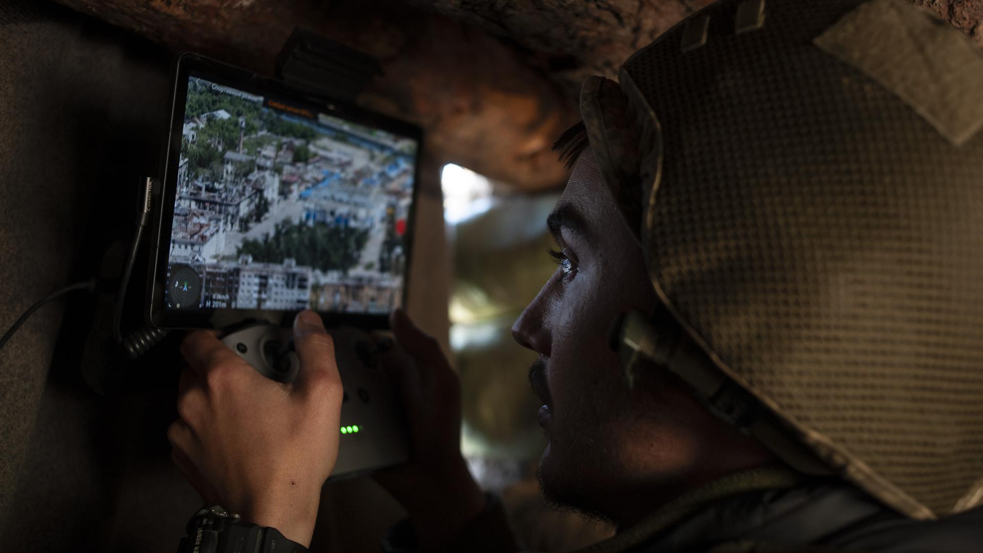 Ein ukrainischer Soldat kontrolliert eine Drohne aus einem Unterstand. 