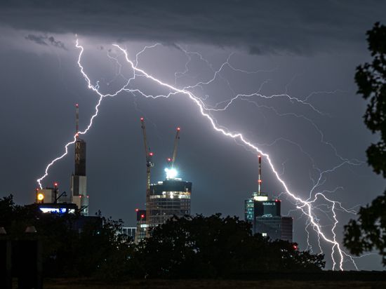 Blitze durchzucken am späten Abend den Himmel über den Frankfurter Hochhäusern. 