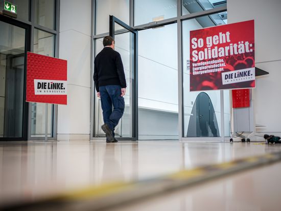 Ein Mitarbeiter des Bundestags geht zum Sitzungssaal der Fraktion von Die Linke auf der Fraktionsebene im Bundestag neben einem Plakat mit der Aufschrift «So geht Solidarität:» . 
