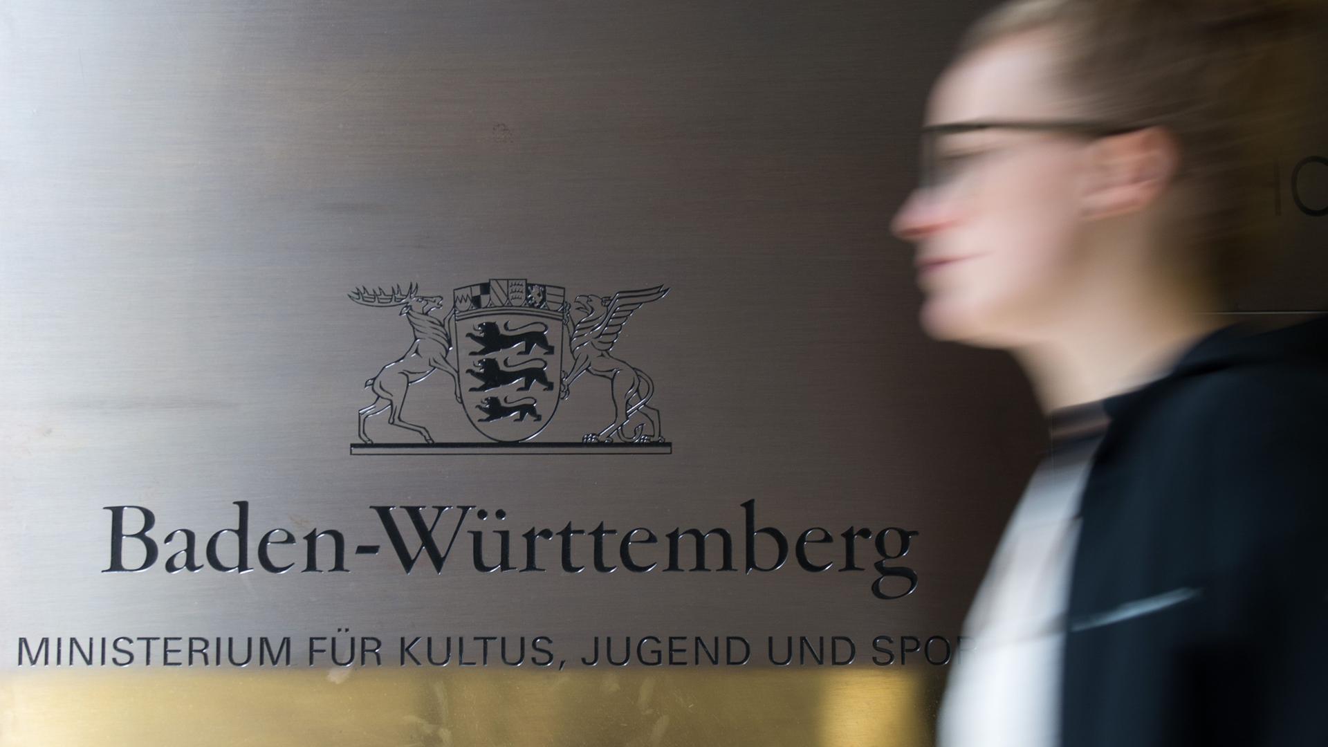  Eine Frau geht in Stuttgart an dem Logo des Ministeriums für Kultus, Jugend und Sport vorbei. 