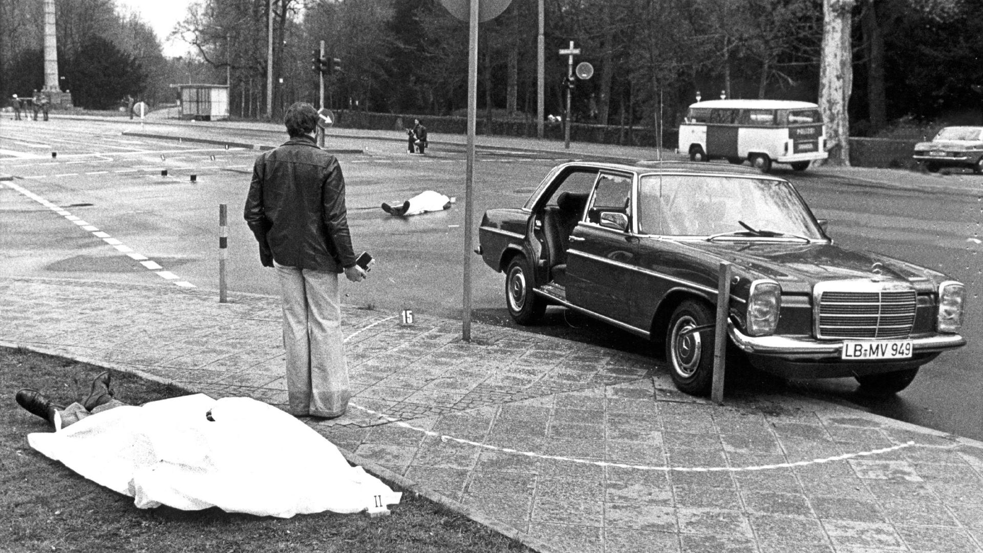 ARCHIV - Die Leichen von Generalbundesanwalt Siegfried Buback (vorne links) und seines Fahrers liegen nach den Todesschüssen am Tatort in Karlsruhe, rechts der Dienstwagen Bubacks (Archivfoto vom 07.04.1977). 