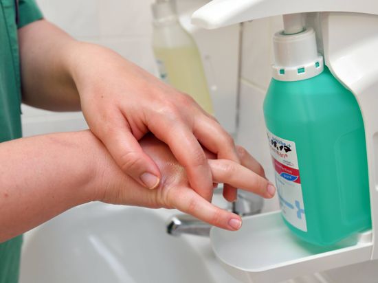 Eine Krankenschwester reinigt sich ihre Hände mit Desinfektionsmittel in einem Kreiskrankenhaus. 
