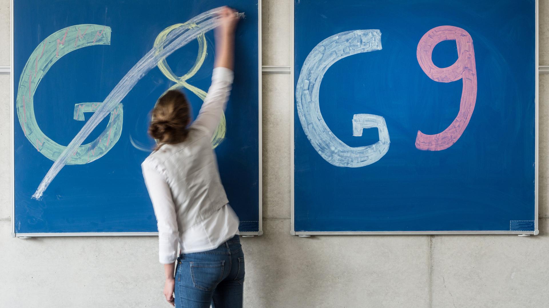 Eine Schülerin der Oberstufe streicht an einem Gymnasium den Schriftzug «G8» an einer Tafel durch. 
