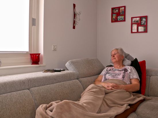 Die 53-jährige Petra Neues aus Baden-Baden liegt auf ihrem Sofa im Wohnzimmer und schaut zum Fenster hinaus.