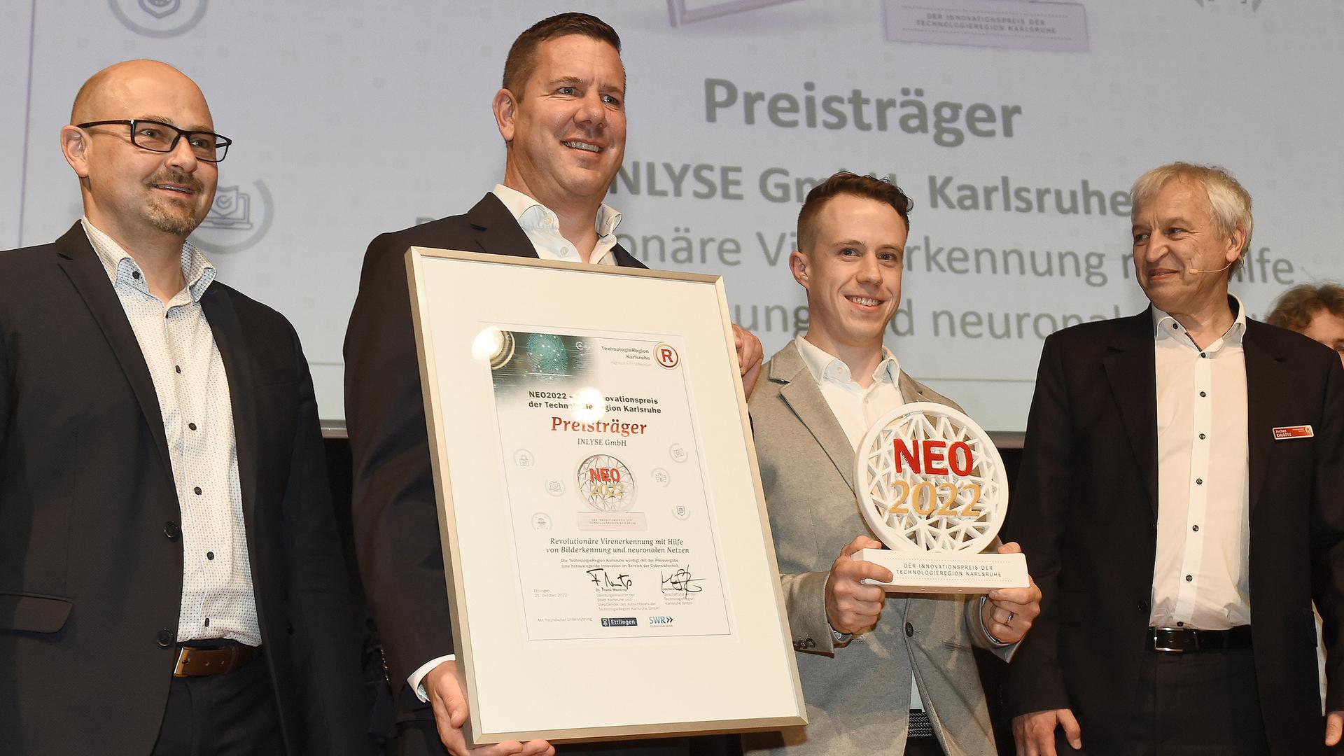 Cyberabwehr gestärkt: Gewinner des NEO2022, Ralf Haubrich und Julian Ziegler (Mitte) von der Firma Inlyse, mit dem Ettlinger Oberbürgermeister Johannes Arnold (links) und Geschäftsführer der Technologieregion Karlsruhe, Jochen Ehlgötz (rechts).