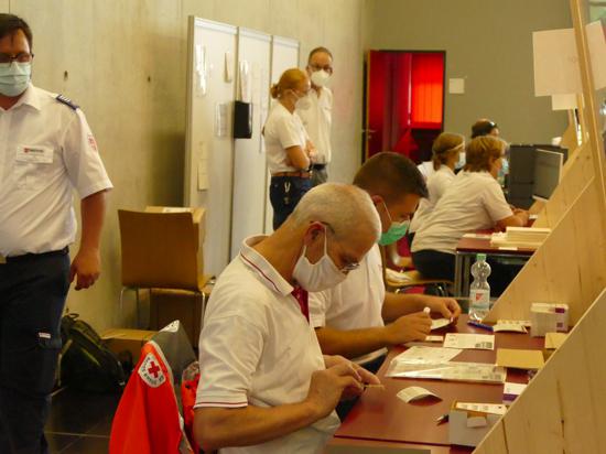 Letzte Vorbereitungen: An mehreren Stationen erledigen Ehrenamtliche des Roten Kreuzes und des Malteser Hilfsdiensts die Formalitäten.