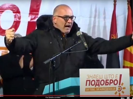 Axel Fischer gestikuliert am Rednerpult bei einer Wahlkampfveranstaltung der Partei VMRO-DPMNE (Innere Mazedonische Revolutionäre Organisation – Demokratische Partei für Mazedonische Nationale Einheit) 2016 im heutigen Nordmazedonien.