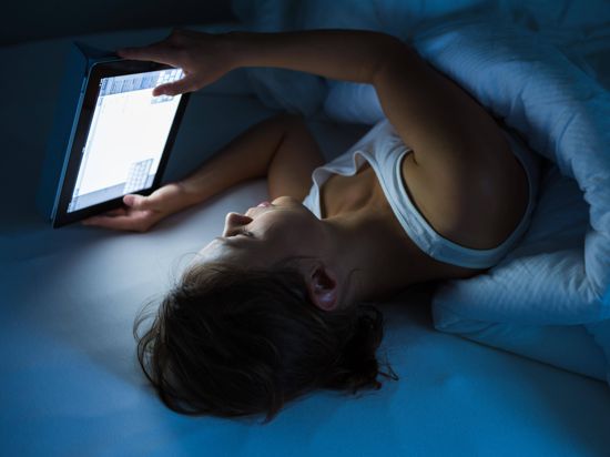Störender Effekt: Die LED-Technik in vielen Geräten strahlt Licht mit einem hohen Blauanteil aus, was beim Einschlafen hinderlich sein kann. Viele Experten empfehlen deswegen, abends im Bett besser ein Buch zu lesen, anstatt über eine längere Zeit auf ein Handy oder ein Tablet zu schauen.