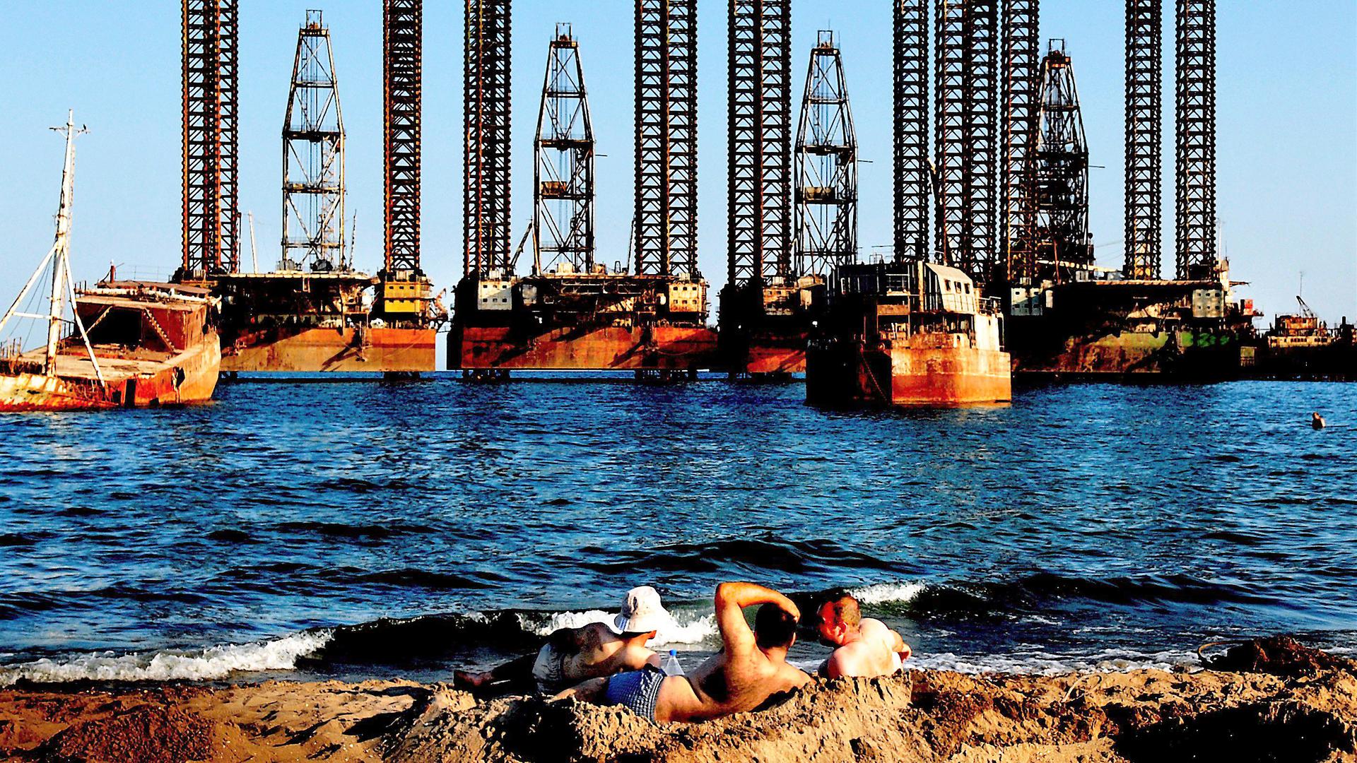 A picture made available 29 July shows workers from Oil platforms enjoy the sun on the beach of Caspian See near Azerbaijan capital city Baku, 23 July 2008. Crude oil prices above 120 US dollars a barrel are abnormal and could fall to around 78 US dollars under the right circumstances, OPEC President Chakib Khelil said in Jakarta on 29 July 2008. EPA/FILIP SINGER +++ dpa-Bildfunk +++
