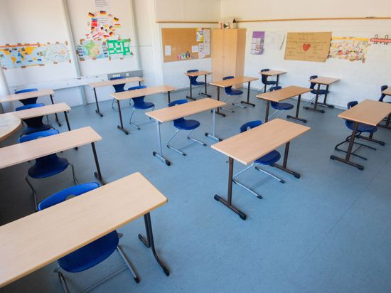 Stühle und Tische stehen im Abstand von jeweils zwei Metern in einem Klassenzimmer.