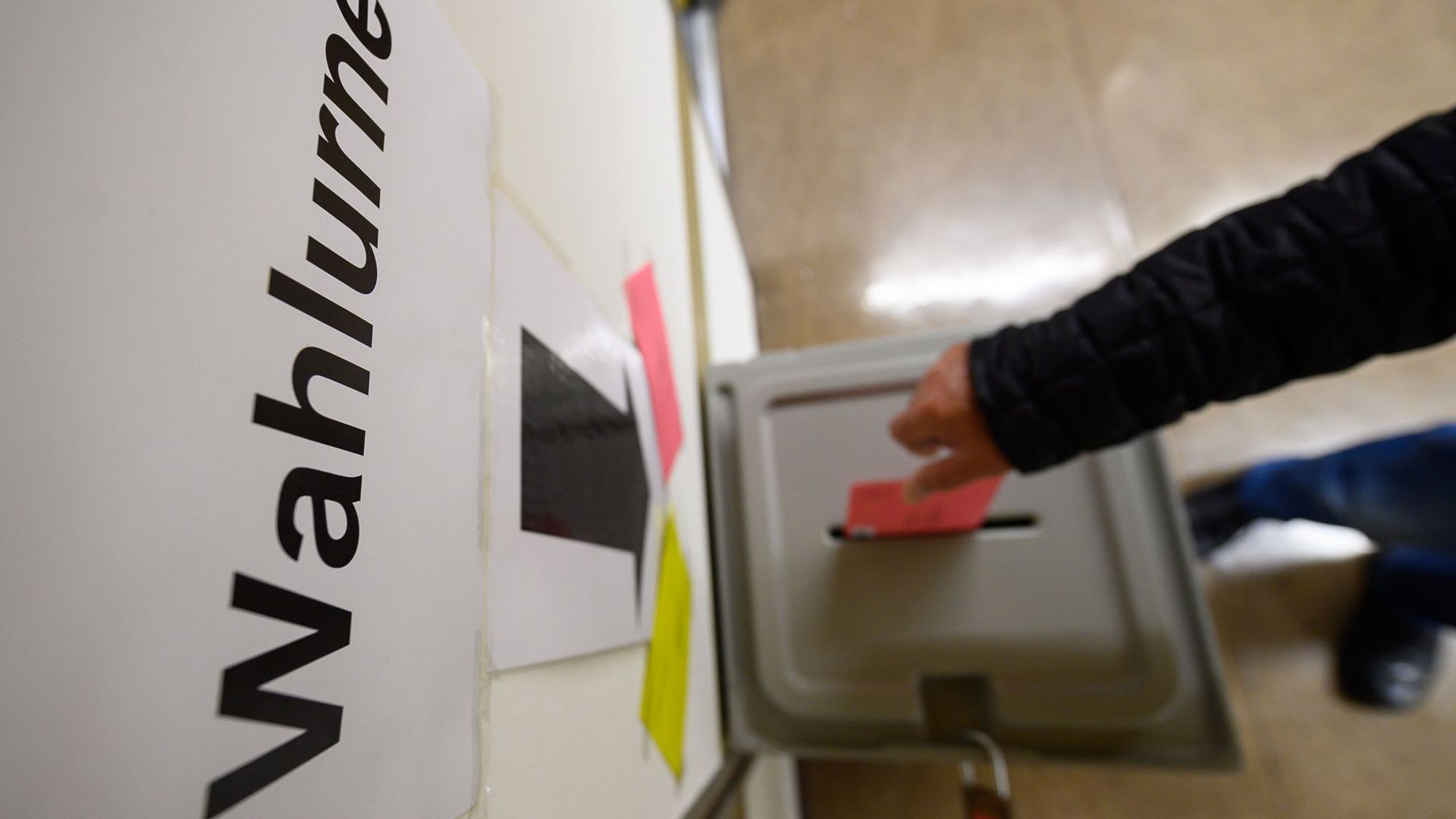 Ein Mann wirft einen Wahlbrief in eine Wahlurne.