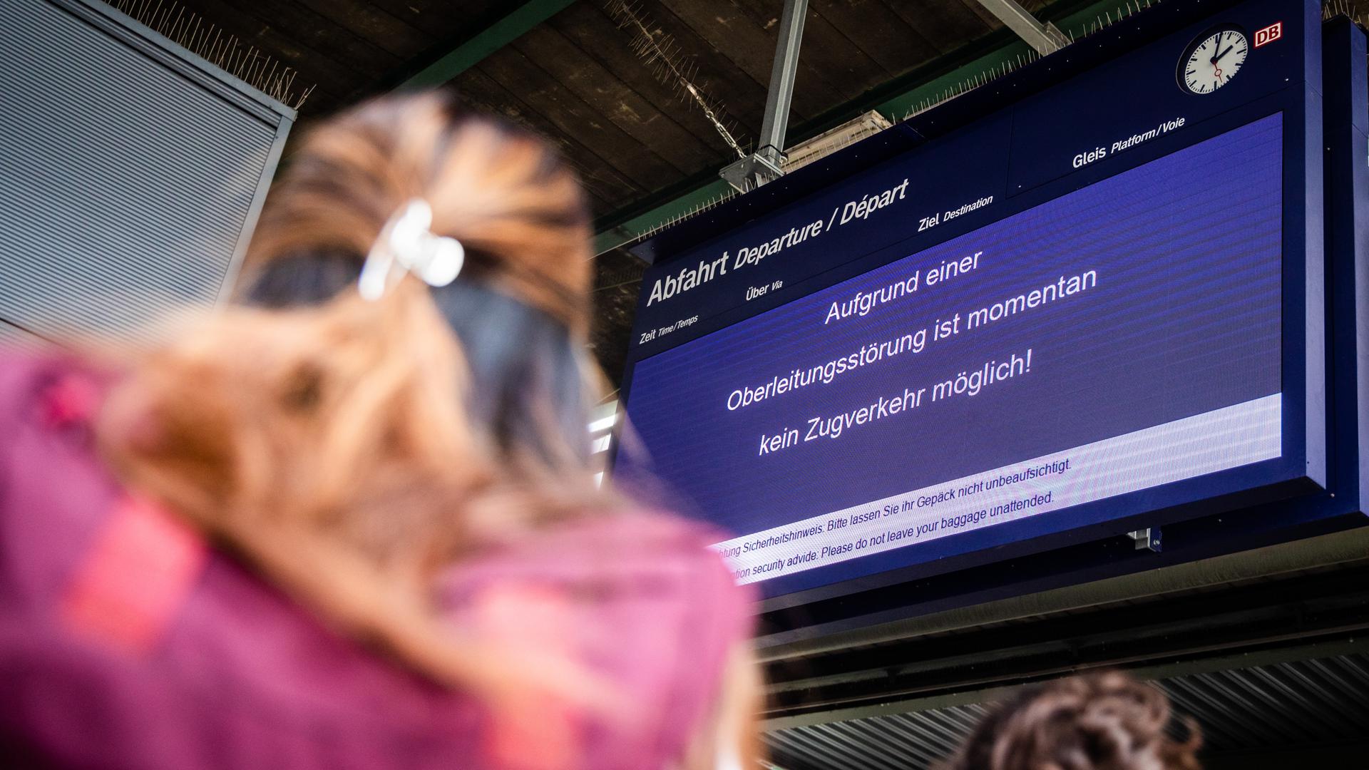  Während Fahrgäste in der Schlange zum DB Infoschalter anstehen, informiert eine Anzeigetafel im Stuttgarter Hauptbahnhof die Fahrgäste darüber, dass der Zugverkehr wegen eines Oberleitungsschadens aktuell nicht möglich ist. 