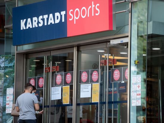 Passanten vor einem Eingang einer Filiale von Karstadt Sports.