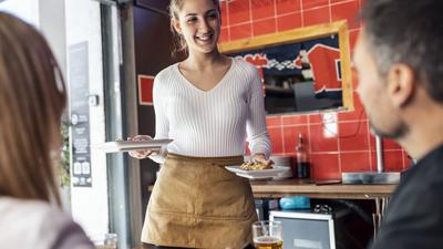 Smiling young woman in restaurant serving food to customers model released, Symbolfoto property released, JSRF02062